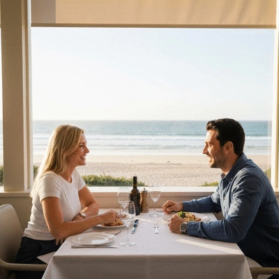 Couple enjoying Italian meal at restaurant with beach view