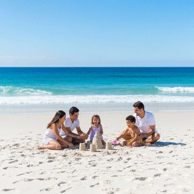 Family playing on Cottesloe Beach with clear blue ocean and white sand